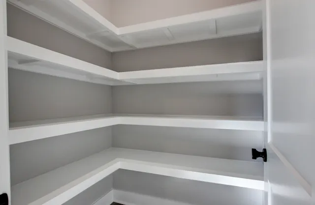 a view of a hallway with stairs and white walls