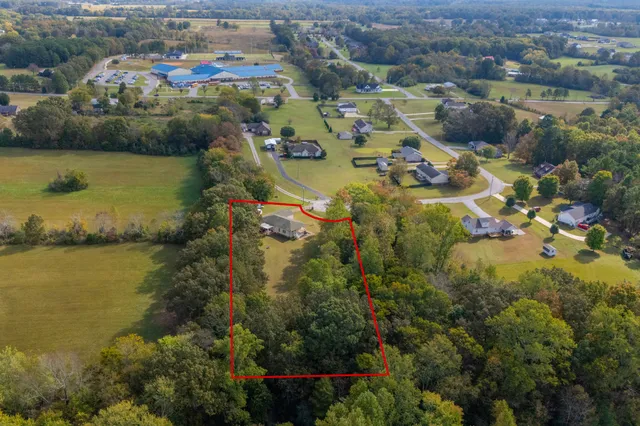 an aerial view of ocean and residential houses with outdoor space