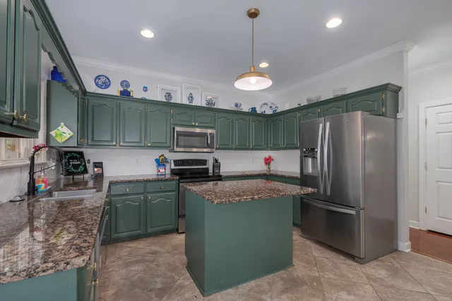 a kitchen with stainless steel appliances granite countertop a refrigerator a stove a sink and a microwave