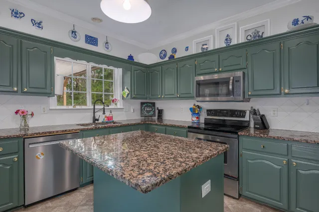 a kitchen with stainless steel appliances granite countertop a sink stove and cabinets