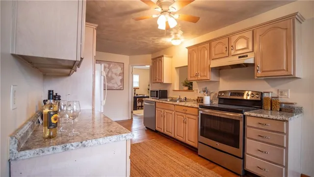 a kitchen with stainless steel appliances granite countertop a sink stove and cabinets