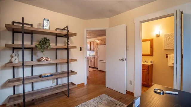 a view of a hallway with wooden floor and furniture
