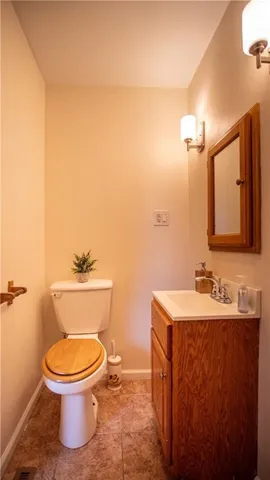 a bathroom with a toilet a sink and mirror