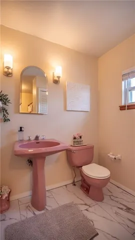 a bathroom with a sink a toilet and mirror