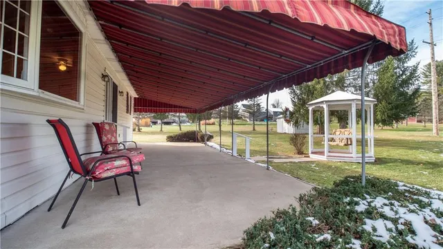 a patio with a table and chairs and potted plants
