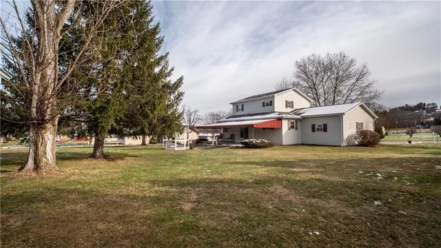 a yellow and red house with a big yard