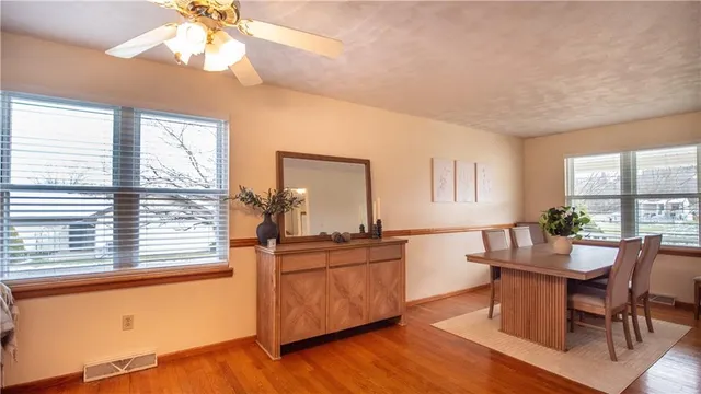 a dining room with wooden floor and a window