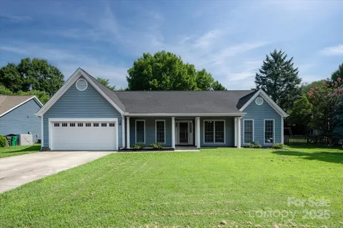 a view of a yard in front of a house with large trees