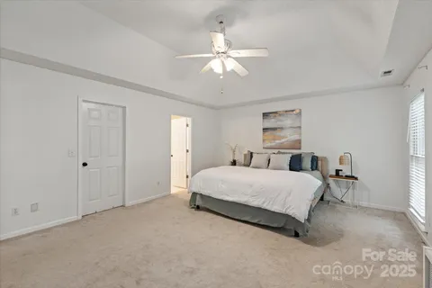 a spacious bedroom with a bed and a chandelier