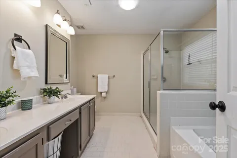 a bathroom with a double vanity sink mirror and shower