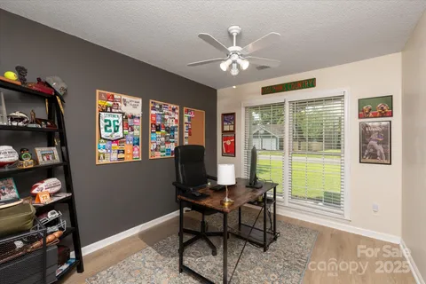 a view of a workspace with furniture and a window