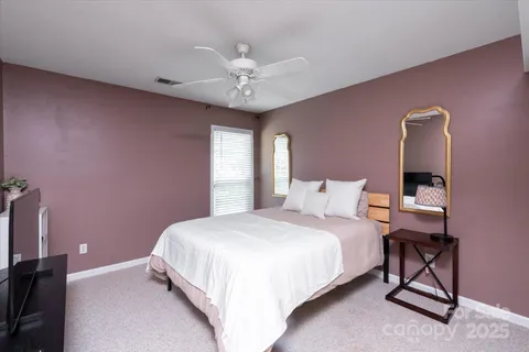 a bedroom with a bed table and chair