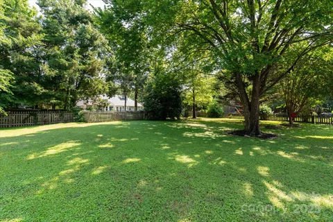 a view of green field with trees in the background