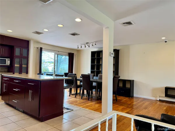 a view of kitchen with kitchen island granite countertop wooden cabinets and stainless steel appliances