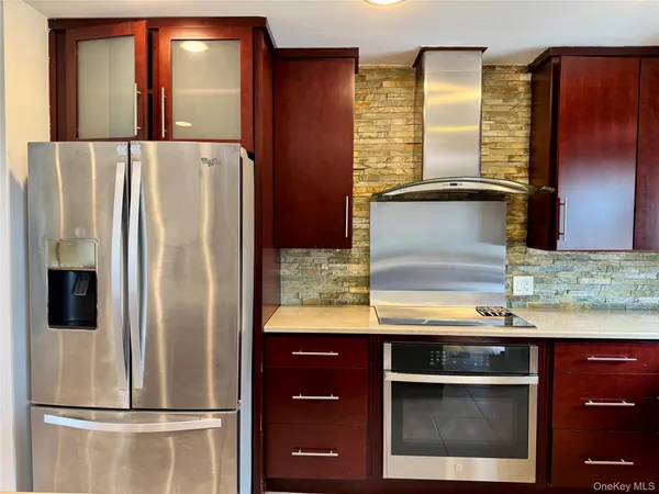 a kitchen with kitchen island a counter top space cabinets and stainless steel appliances