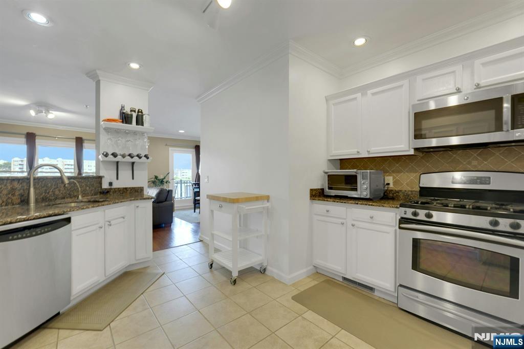 155 The Promenade Edgewater, NJ 07020 - Photo 15 of 31 a kitchen with counter top space cabinets and stainless steel appliances