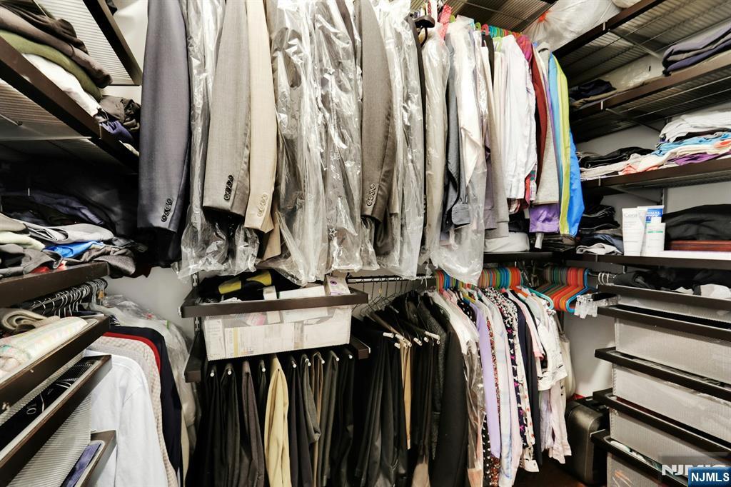 155 The Promenade Edgewater, NJ 07020 - Photo 24 of 31 a view of walk in closet with clothes and shoes