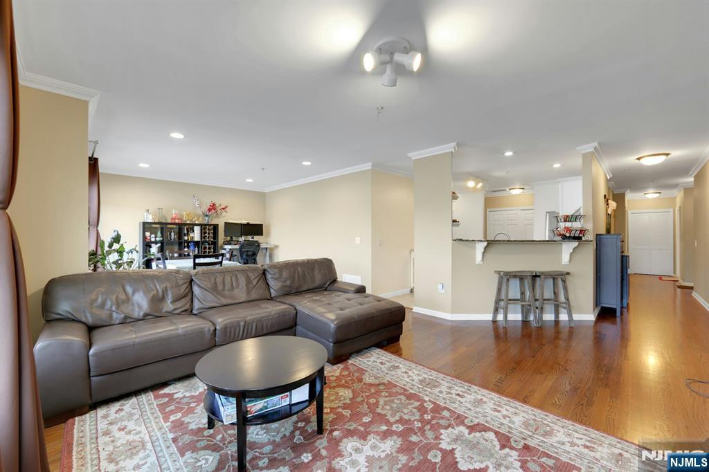 155 The Promenade Edgewater, NJ 07020 - Photo 10 of 31 a living room with furniture and a dining table with wooden floor