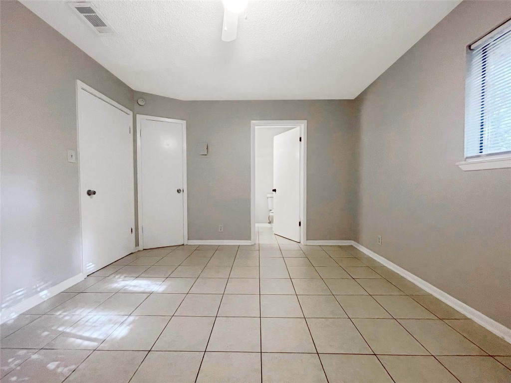 2503 Cecil Drive, Unit C Austin, TX 78744 - Photo 4 of 8 a view of an empty room with window and chandelier fan