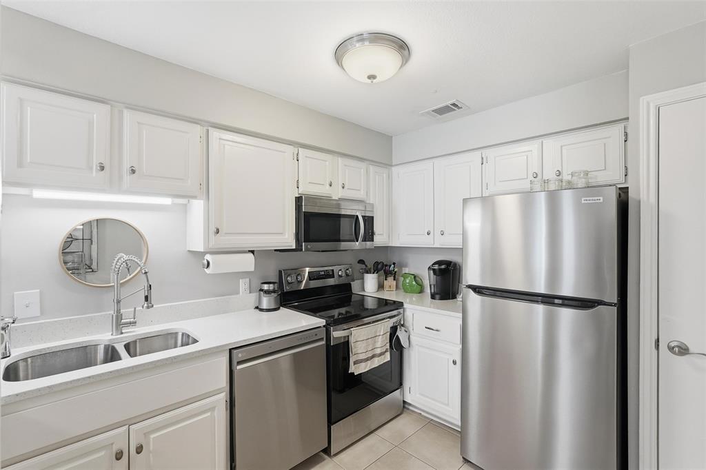 6220 Bentwood Trail, Unit 908 Dallas, TX 75252 - Photo 12 of 40 a kitchen with refrigerator a sink and cabinets