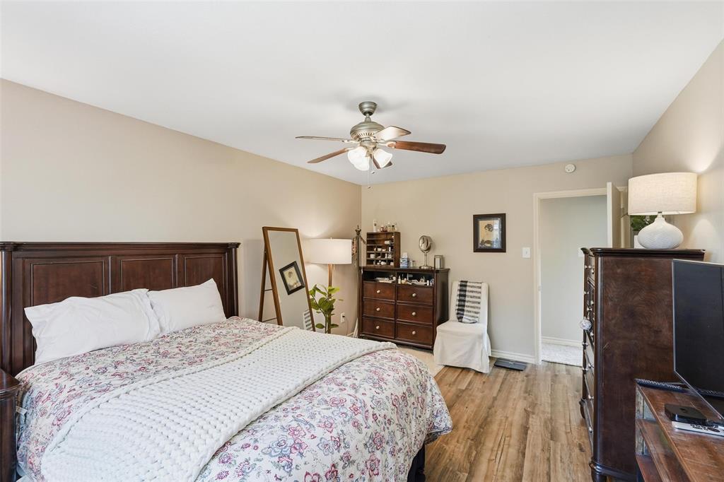6220 Bentwood Trail, Unit 908 Dallas, TX 75252 - Photo 24 of 40 a bedroom with a bed and wooden floor