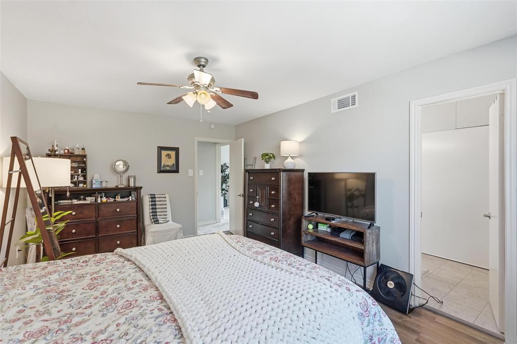 6220 Bentwood Trail, Unit 908 Dallas, TX 75252 - Photo 25 of 40 a bedroom with a bed and a flat tv screen on dresser