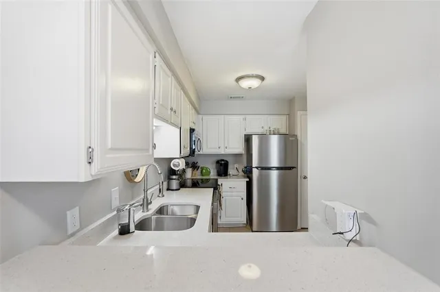 a kitchen with stainless steel appliances a sink and a refrigerator