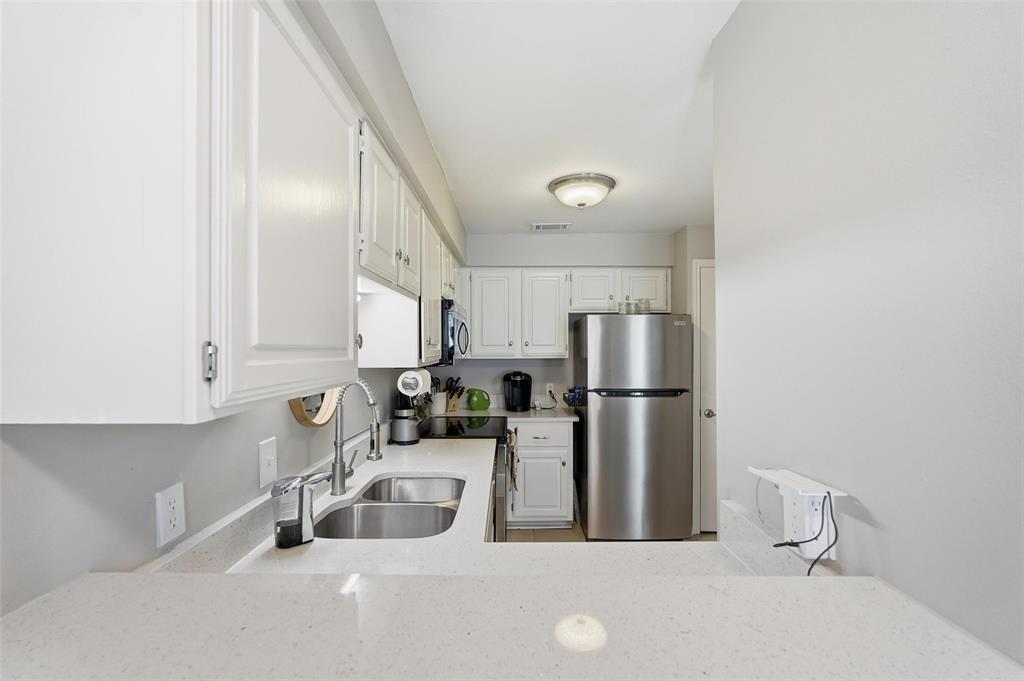 6220 Bentwood Trail, Unit 908 Dallas, TX 75252 - Photo 9 of 40 a kitchen with stainless steel appliances a sink and a refrigerator
