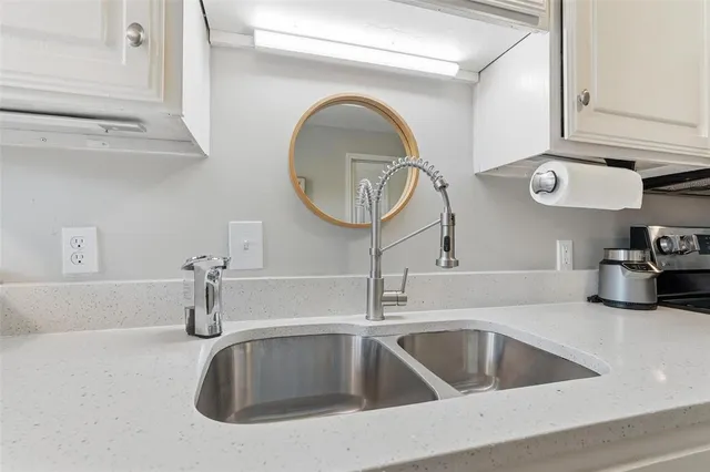 a kitchen with a sink and a mirror
