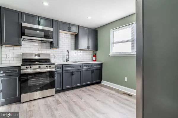 a kitchen with stainless steel appliances a stove sink microwave and cabinets