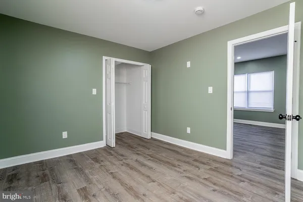 an empty room with wooden floor and closet