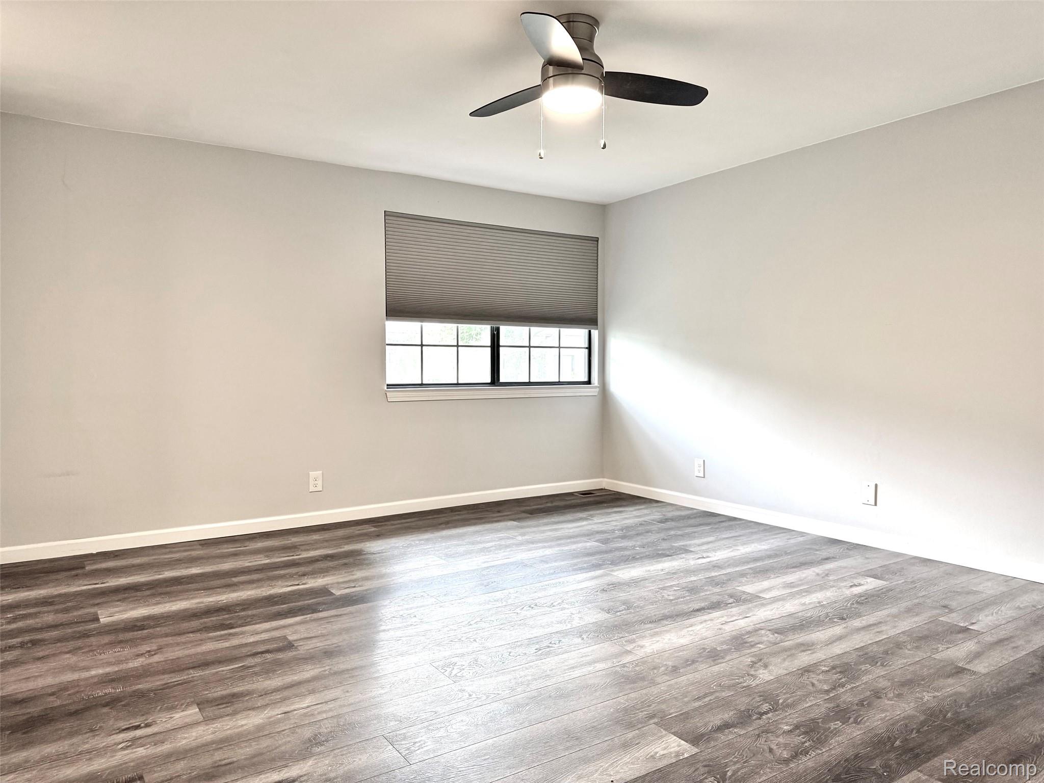 2852 Trailwood Drive Rochester, MI 48309 - Photo 17 of 28 Wood-finish flooring, neutral wall tones, window with horizontal blinds, and a ceiling fan with integrated lighting