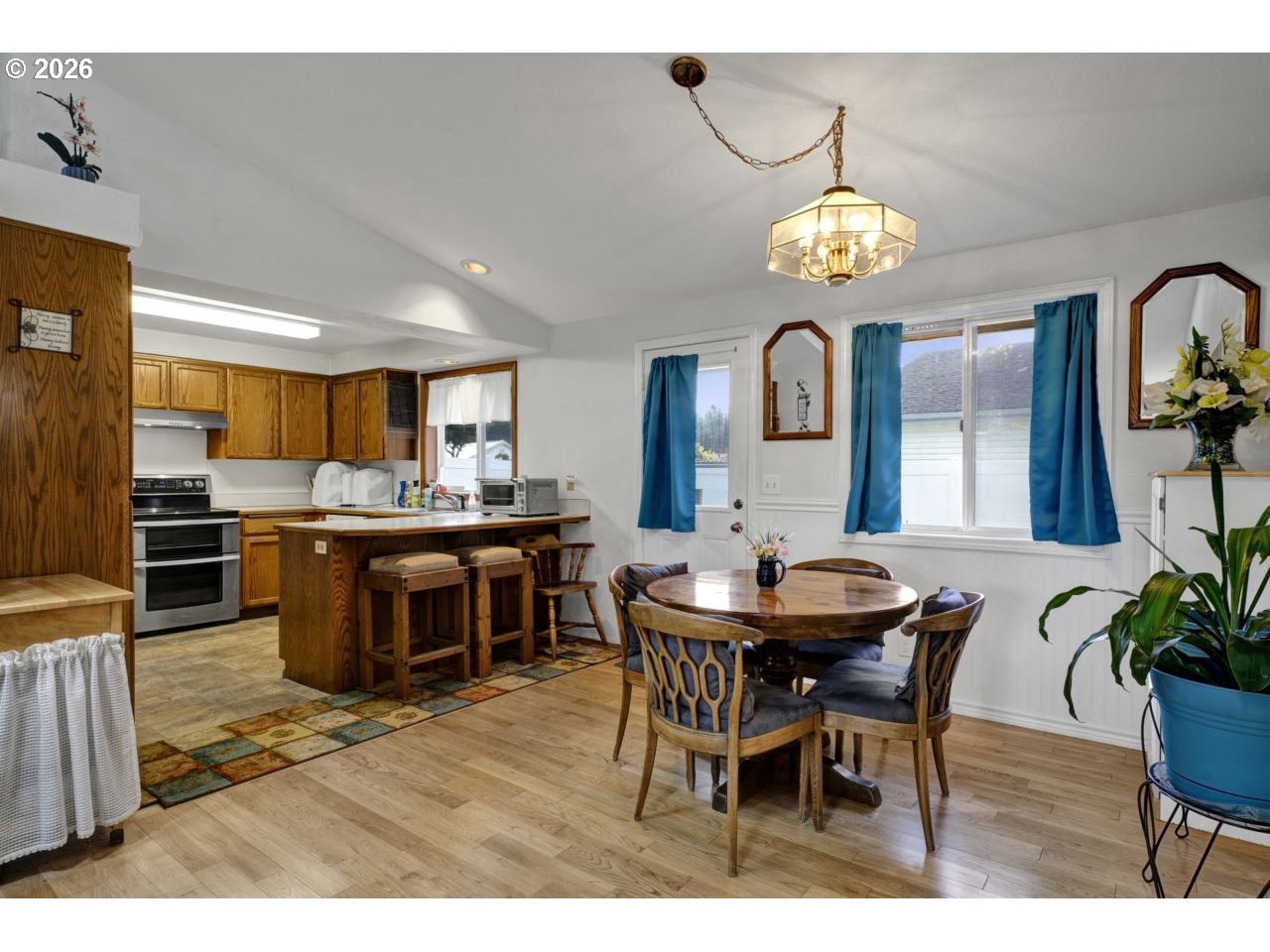 1960 40th Street Florence, OR 97439 - Photo 19 of 48 a view of a dining room and kitchen with furniture a chandelier and wooden floor