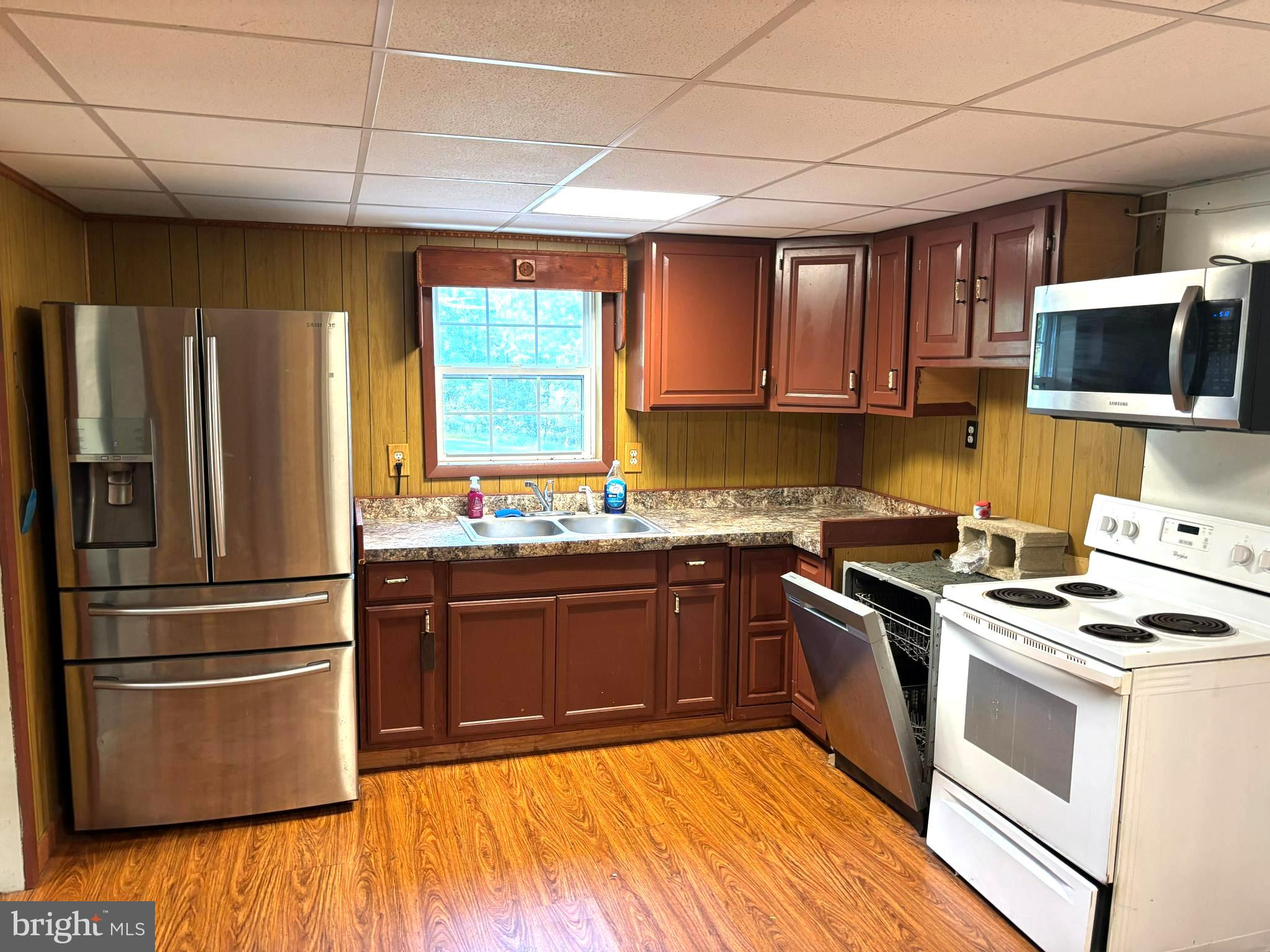 2600 Middle Cove Road Mathias, WV 26812 - Photo 11 of 30 a kitchen with stainless steel appliances granite countertop a stove a sink dishwasher a refrigerator and cabinets with wooden floor