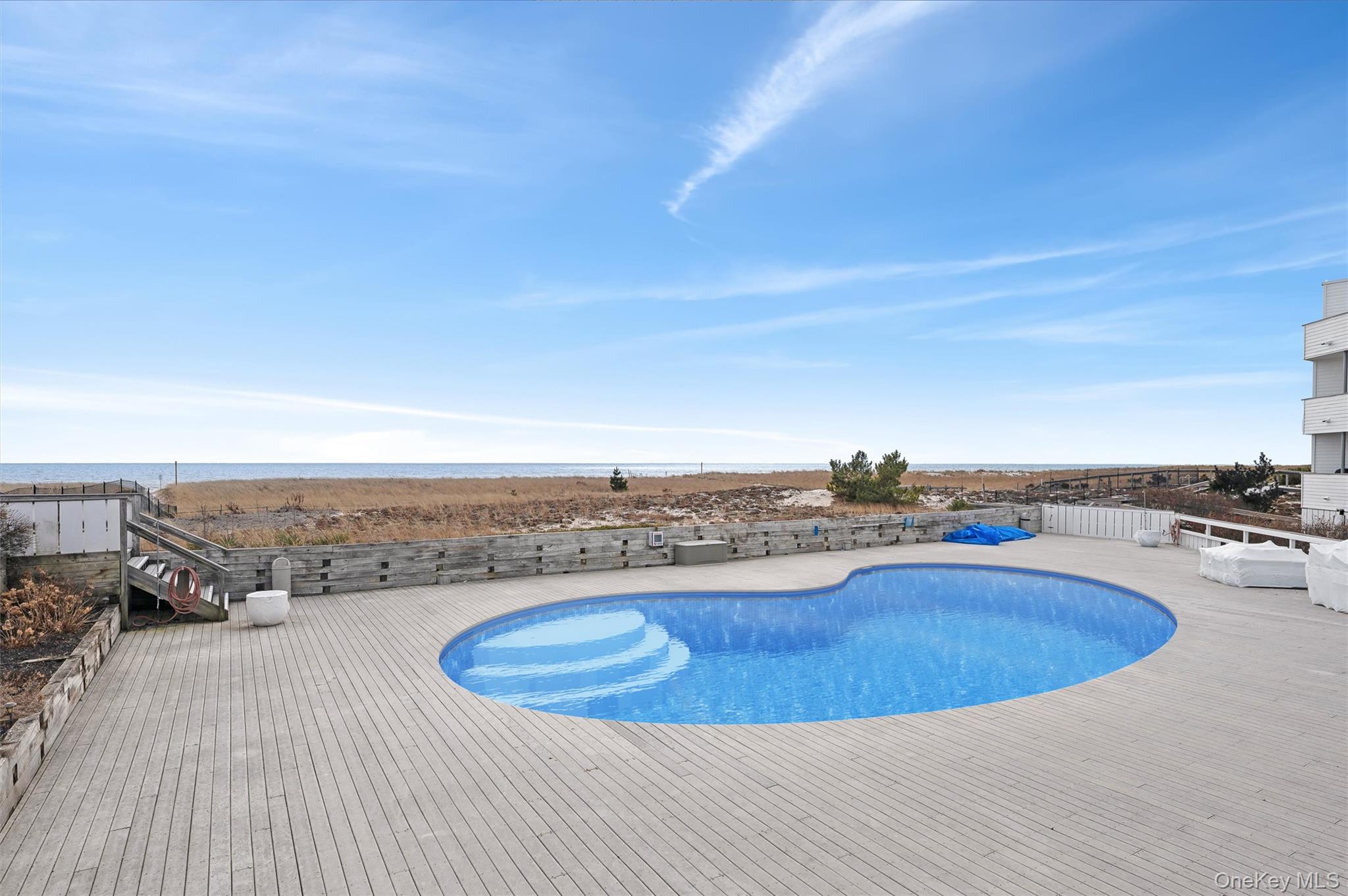 259 Dune Road, Unit 137 Westhampton Beach, NY 11978 - Photo 16 of 16 a view of a swimming pool and an ocean view