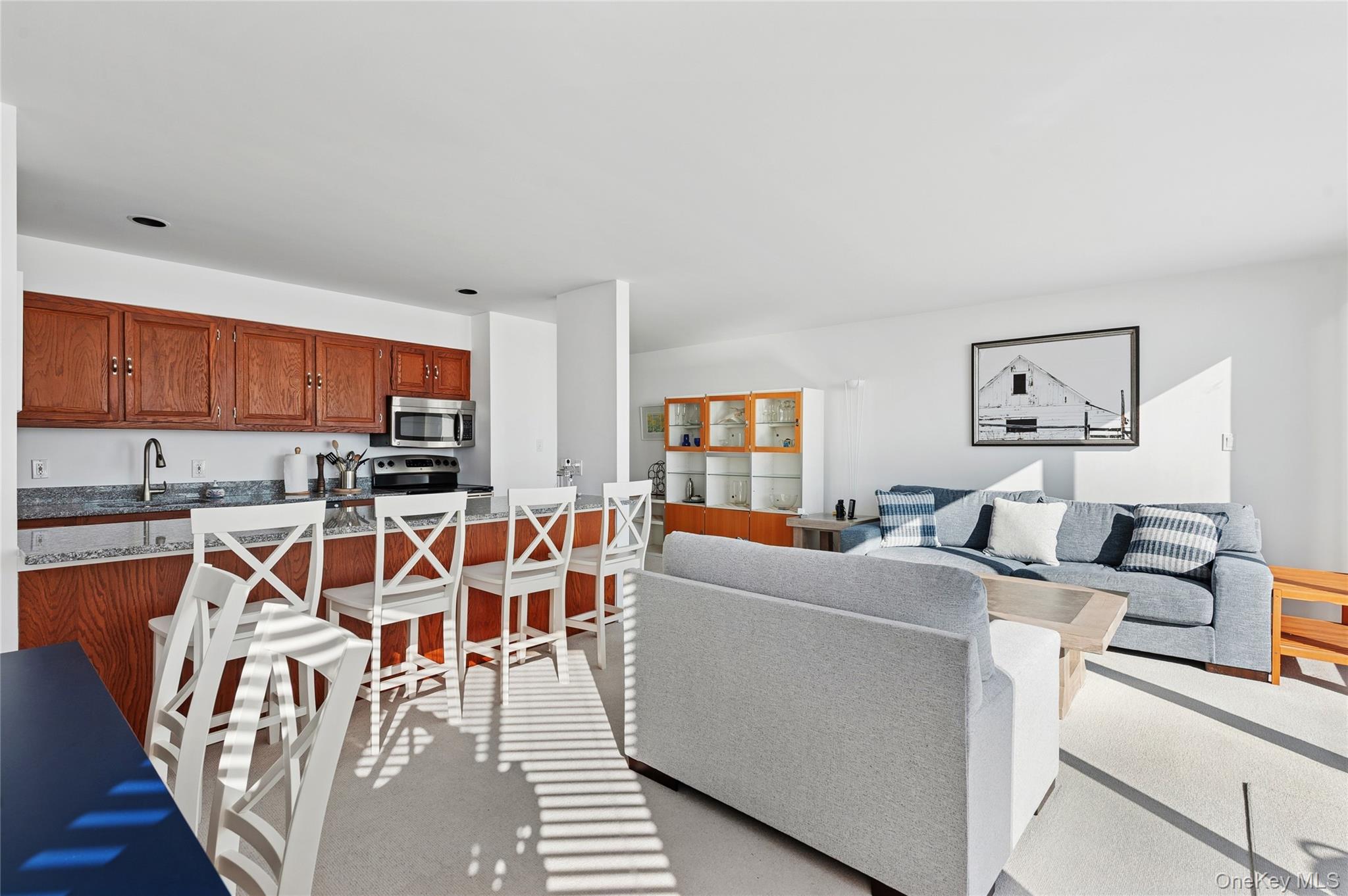 259 Dune Road, Unit 137 Westhampton Beach, NY 11978 - Photo 5 of 16 a view of a dining room with furniture a kitchen and chandelier