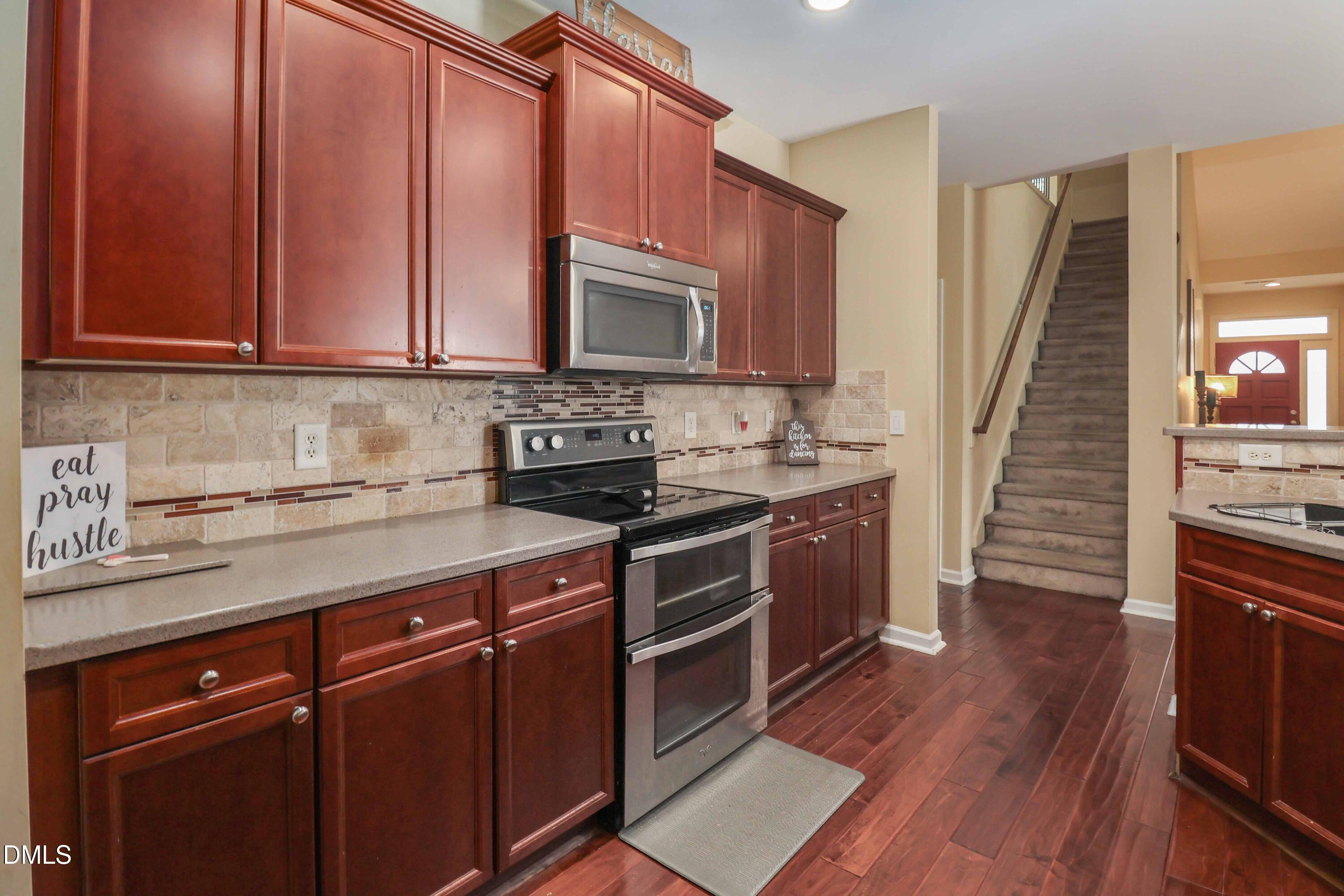 3152 Landing Falls Lane Raleigh, NC 27616 - Photo 10 of 29 a kitchen with stainless steel appliances granite countertop a stove a sink and a microwave