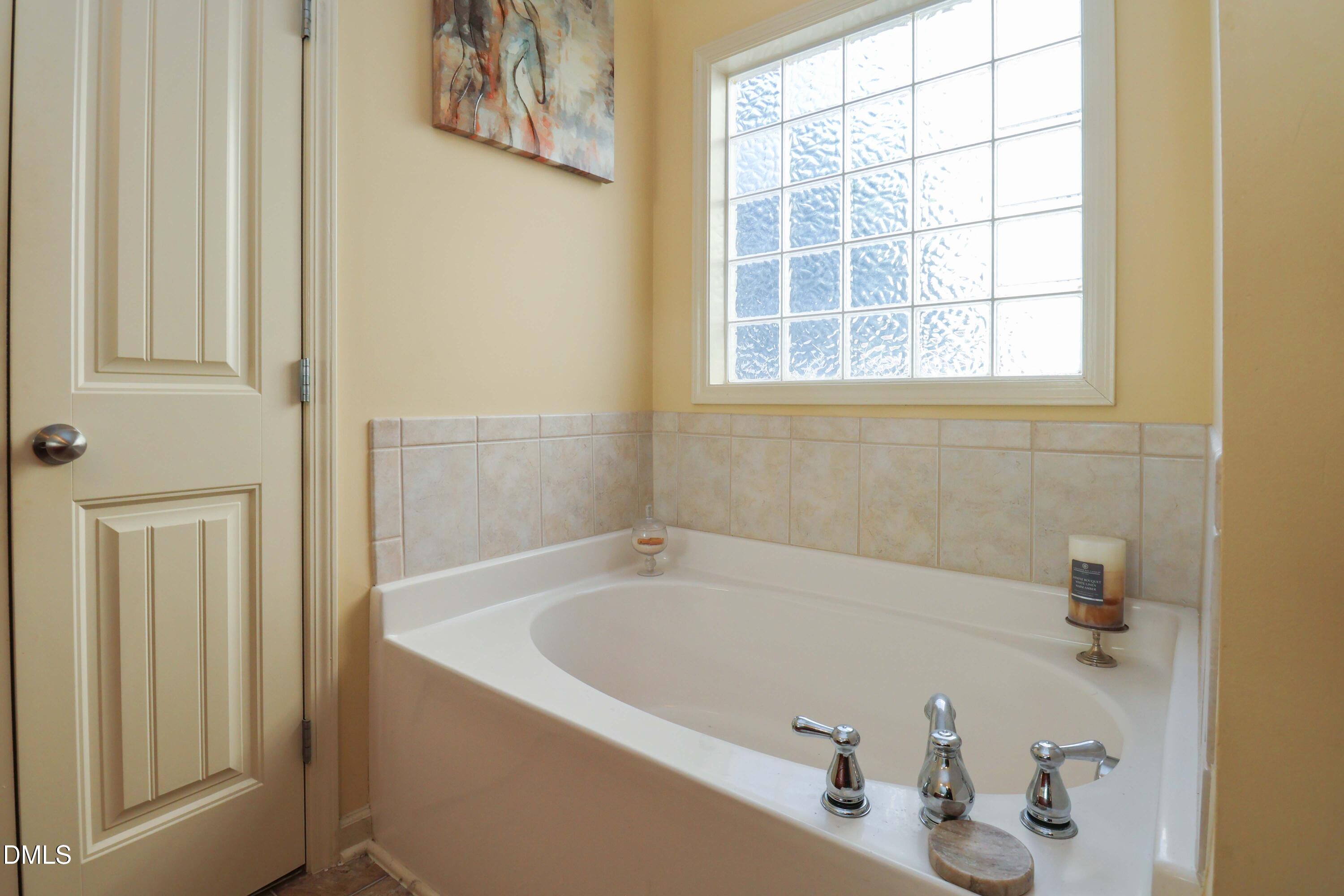 3152 Landing Falls Lane Raleigh, NC 27616 - Photo 16 of 29 a white bath tub sitting in a bathroom next to a window