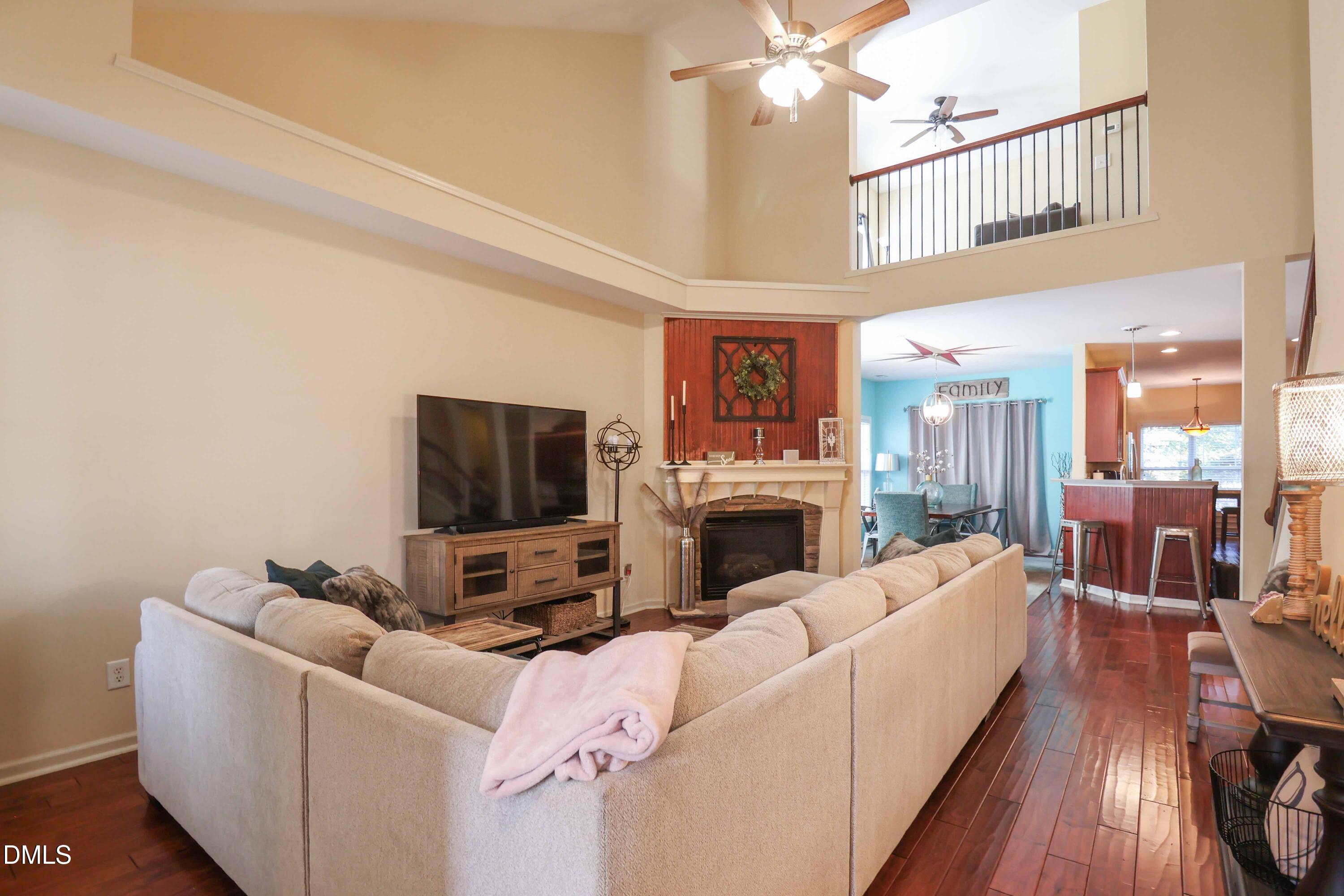 3152 Landing Falls Lane Raleigh, NC 27616 - Photo 4 of 29 a living room with furniture a fireplace and a flat screen tv