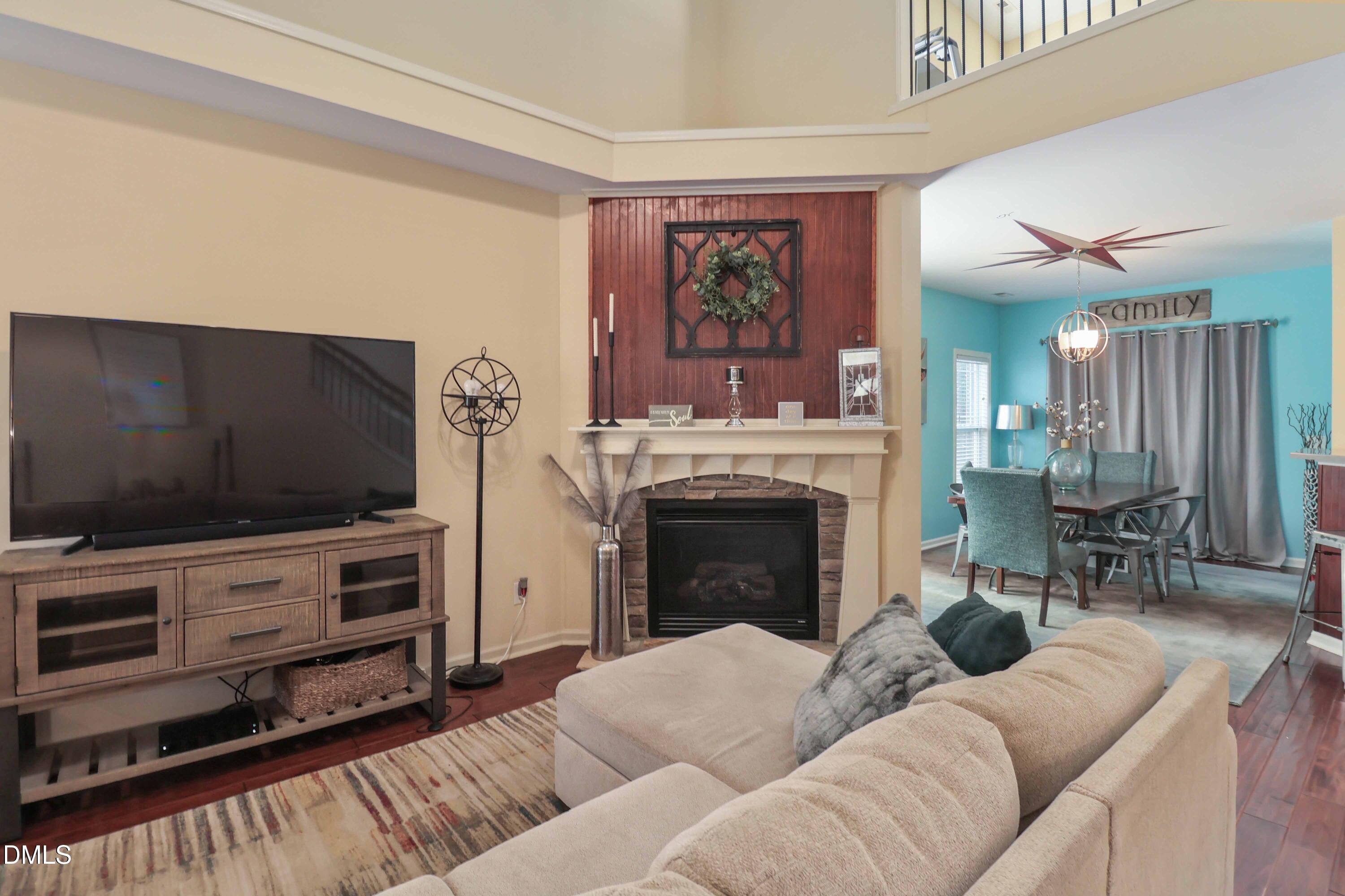 3152 Landing Falls Lane Raleigh, NC 27616 - Photo 6 of 29 a living room with furniture a flat screen tv and a fireplace