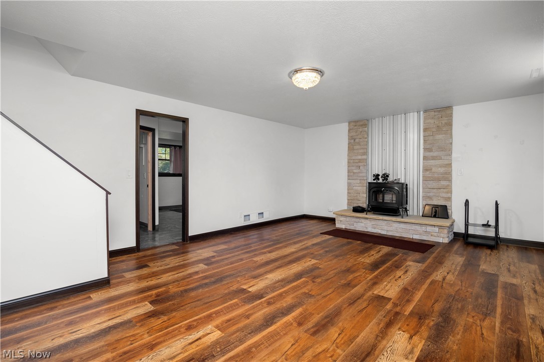 6760 Mason Road Berlin Heights, OH 44814 - Photo 27 of 49 Unfurnished living room featuring a wood stove and dark wood-style floors