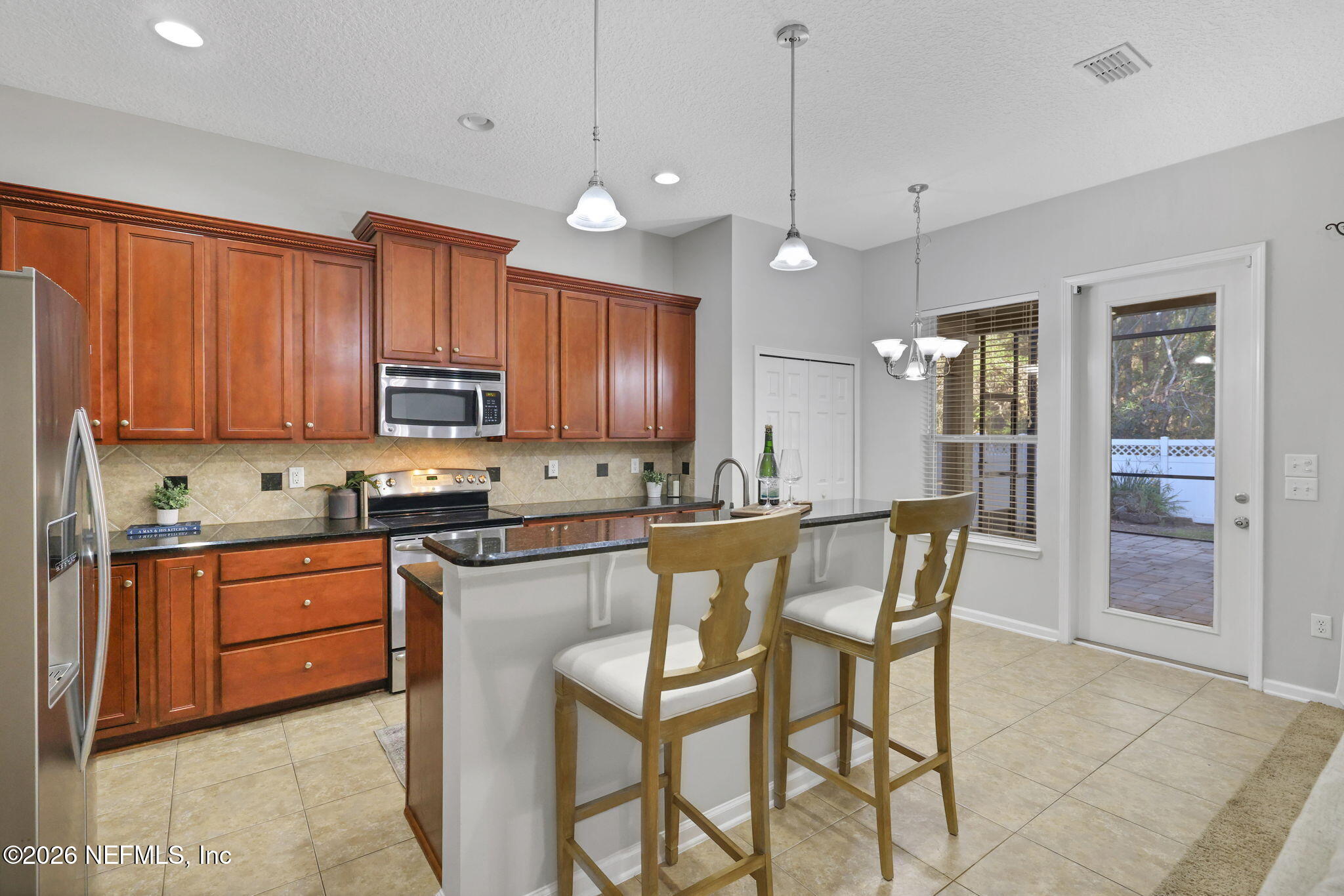511 Roserush Lane Jacksonville, FL 32225 - Photo 14 of 61 a kitchen with stainless steel appliances granite countertop wooden cabinets a stove a sink a dining table and chairs