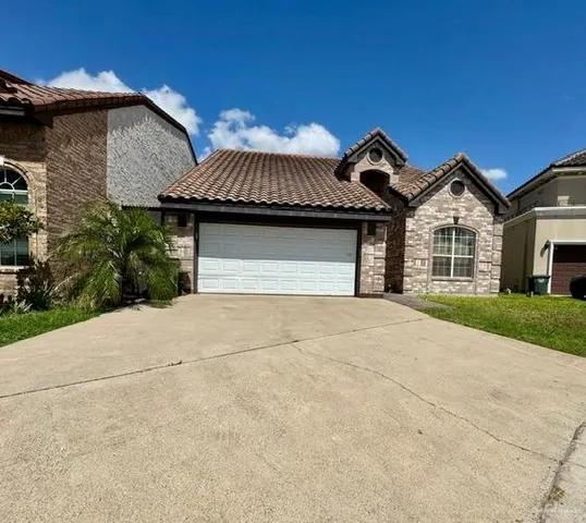 a front view of a house with a garden and garage