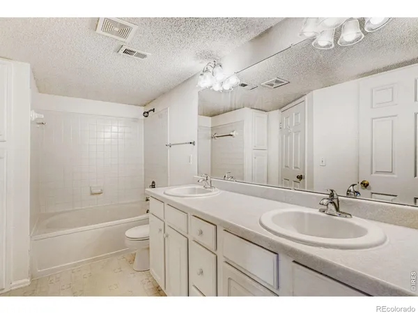 a bathroom with a sink a toilet a mirror and shower