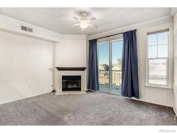 a view of empty room with fireplace and fan