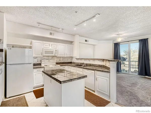 a kitchen with stainless steel appliances kitchen island a sink stove and refrigerator