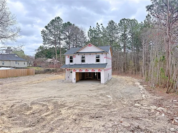 a view of backyard of house with wooden fence