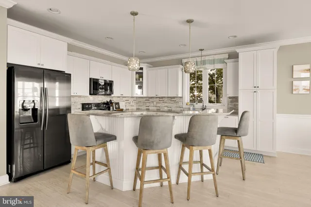 a kitchen with stainless steel appliances kitchen island granite countertop a dining table chairs and a refrigerator