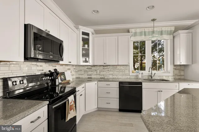 a kitchen with stainless steel appliances granite countertop a sink stove and microwave