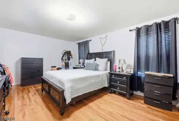 a bedroom with a bed and a flat tv screen on dresser